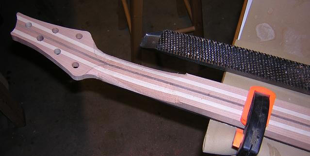 Carving the neck of the guitar.