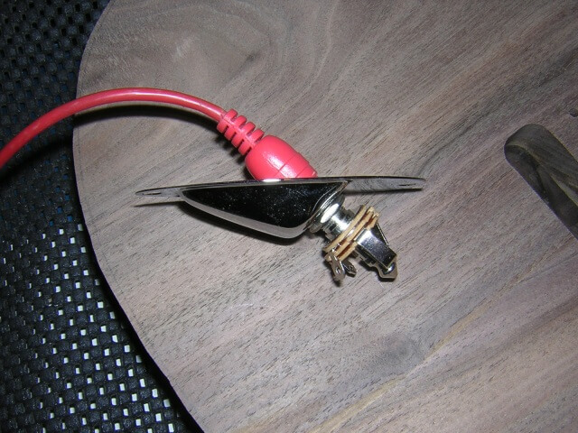 How far the guitar cable goes into the output jack.
