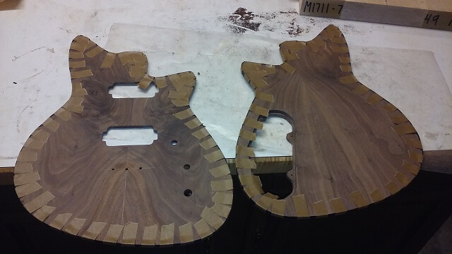 The body pieces with tape holding the binding in place as the glue dries.