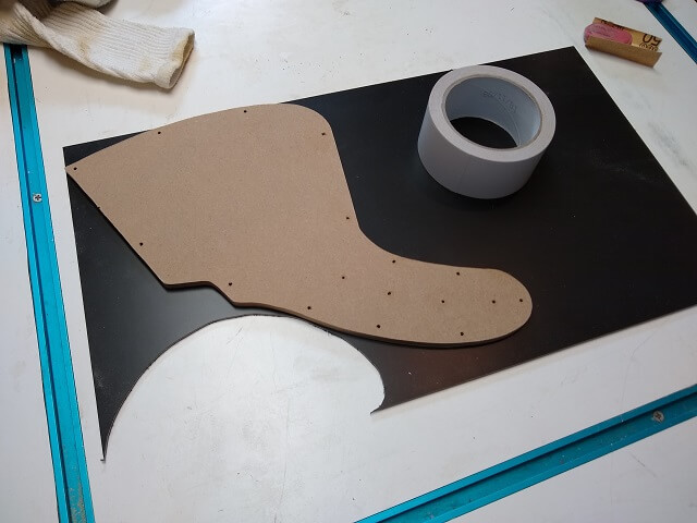 Fitting the pickguard template on the plastic stock.