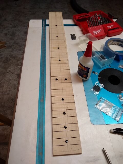 Gluing the dot inlays in place.