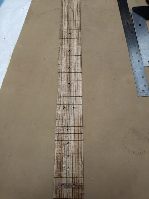 All of the fretboard dot holes drilled.