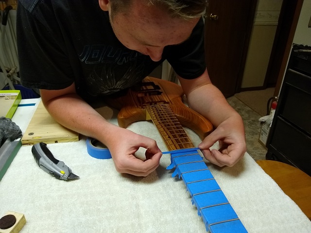 Taping off the fretboard.