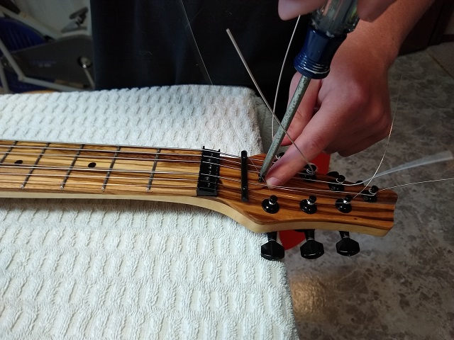 Installing the truss rod cover.