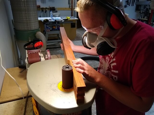 Sanding the headstock face smooth.