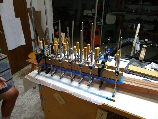 The fretboard glued in place with a ton of clamps holding it secure.