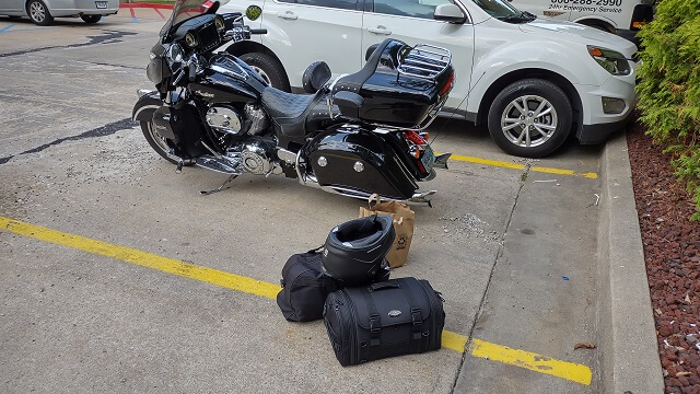 My motorcycle parked outside the hotel, and my luggage ready to go up to the room.
