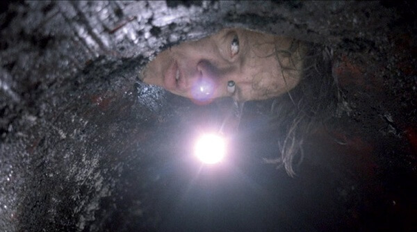 The Shawshank Redemption: Andy peering into the sewer pipe.