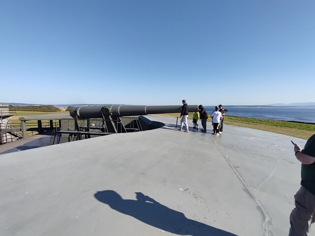 A group of kids looking at one of the guns.