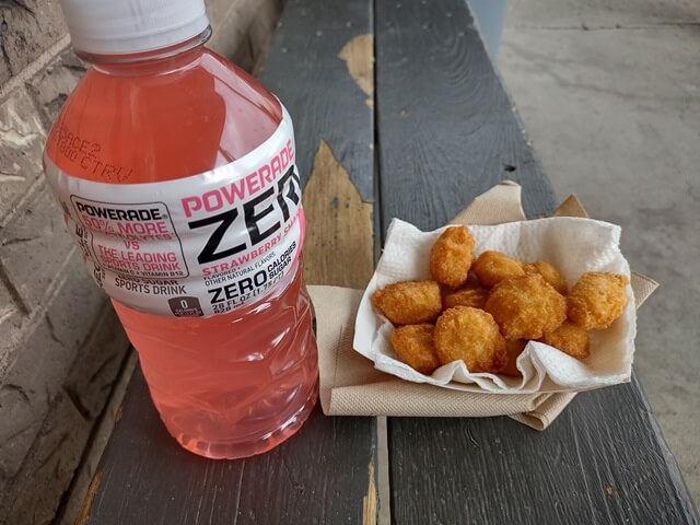 A snack of Powerade and some potato cheddar bites.