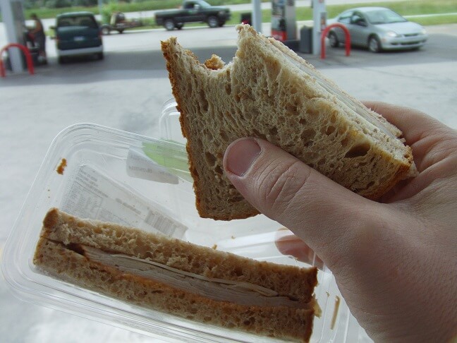 Eating a sandwich at the gas station.
