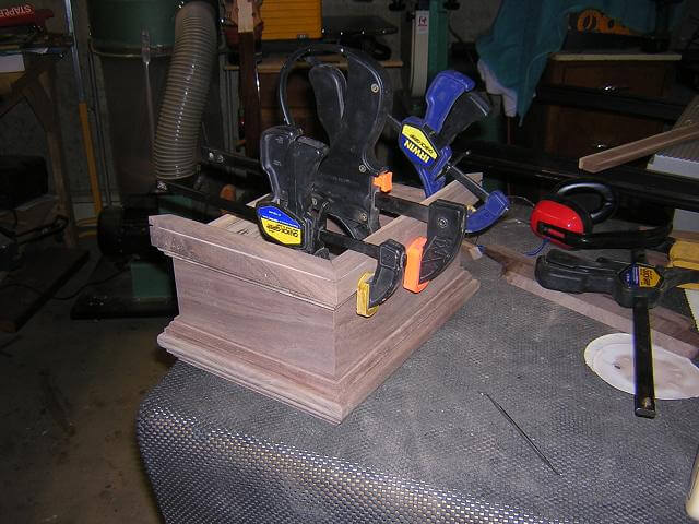 Gluing the mitered base pieces to the urn.