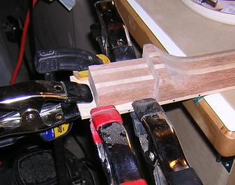 Gluing the wedge to the end of the fretboard.