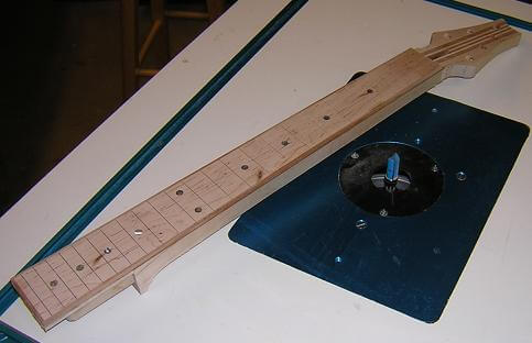 Trimming the sides of the neck flush with the fretboard.