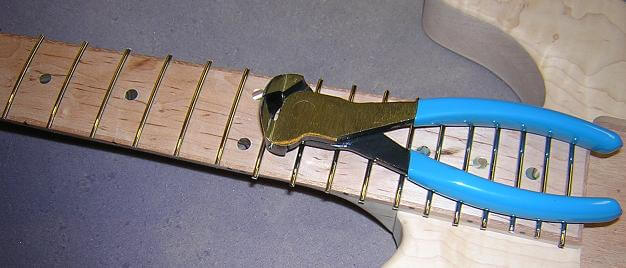 Cutting the fret ends flush.