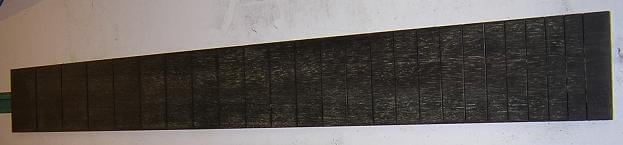 The fretboard with all the fret slots cut.