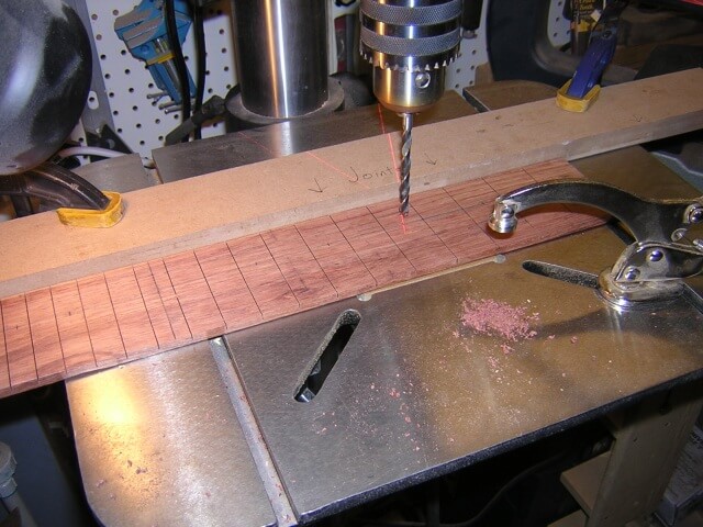 Drilling the holes for the dot inlays on the fretboard.