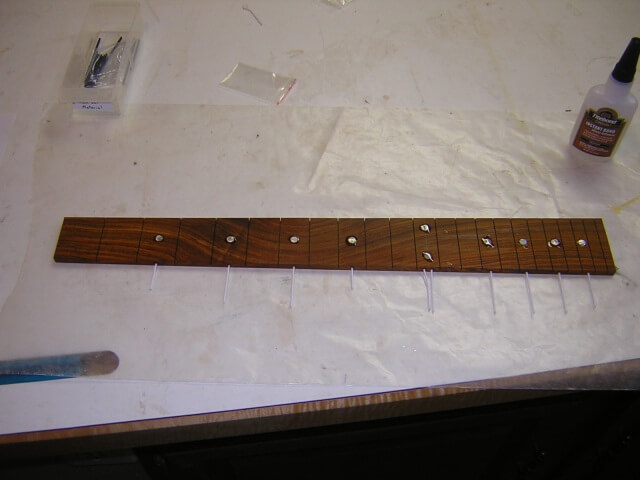 Gluing in the fretboard dot markers.