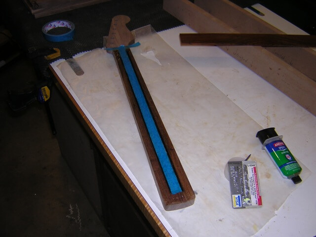 Spreading the epoxy used to glue the fretboard in place.
