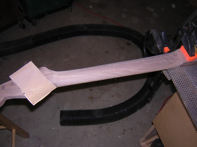 Sanding the neck smooth after carving.