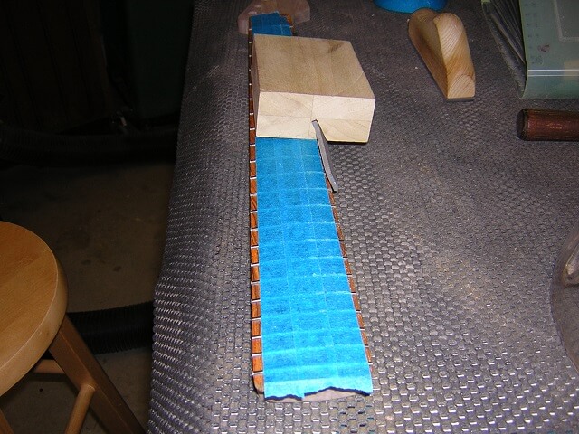 Beveling the edge of the frets.