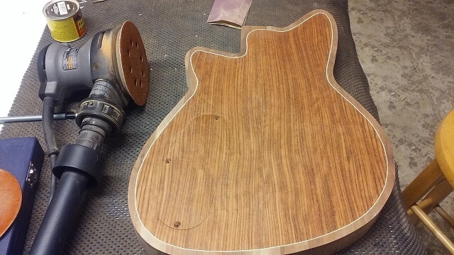 Sanding the back of the guitar.