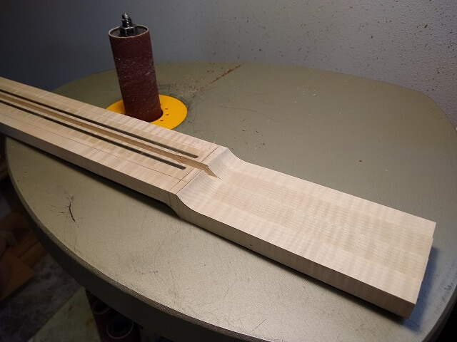 Sanding the headstock transition smooth.