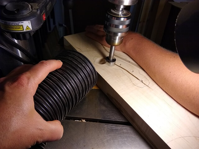 Removing the bulk of the wood from the control cavity at the drill press.