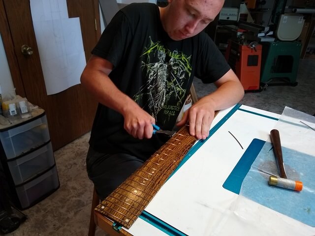 Trimming the ends of the frets flush.