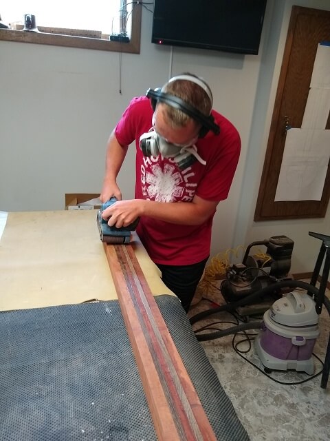 Rough flattening one side of the neck blank with the belt sander.