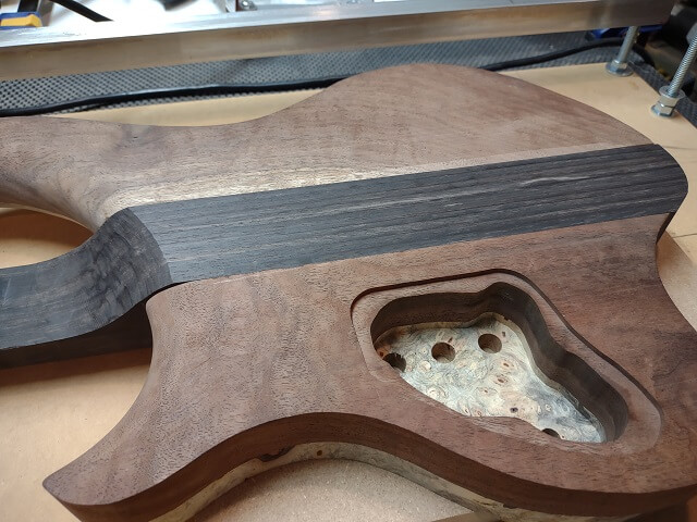 The back of the ebony leveled with the walnut body wings.