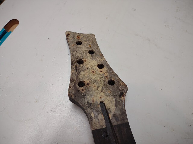 The tuner holes drilled in the headstock.
