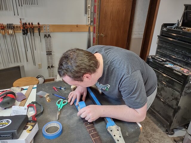 Taping the face of the fretboard to protect it during gluing.