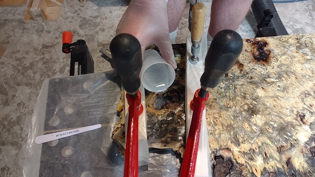 Pouring the resin into the knot hole in the buckeye burl.