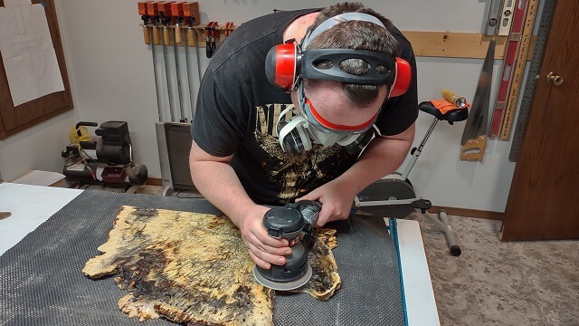 Sanding the buckeye burl smooth after the holes were filled with resin.