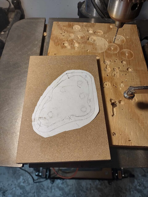 Drilling holes in the template so the scroll saw blade can pass through.