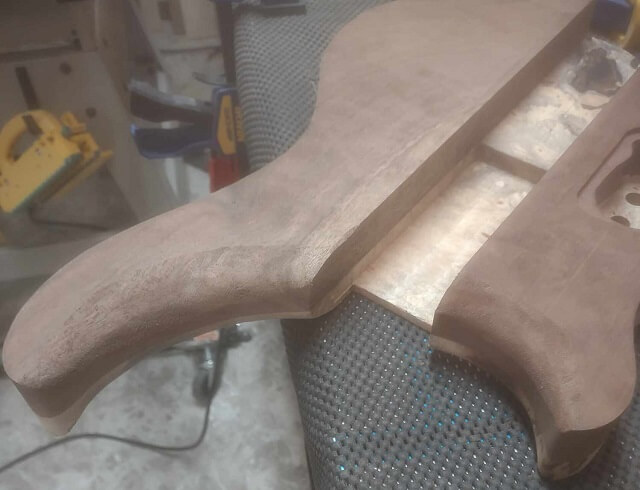 The completed carve of the inner upper horns on the bottom of the guitar.