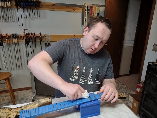 Polishing the frets.