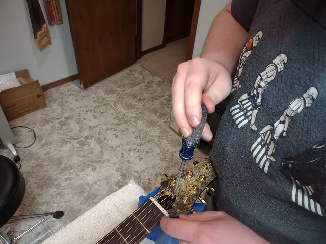 Installing the truss rod cavity cover.