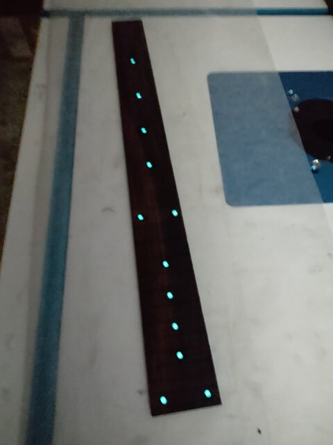 The fret dot markers glowing.