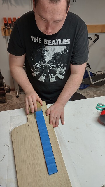 Beveling the edges of the frets.